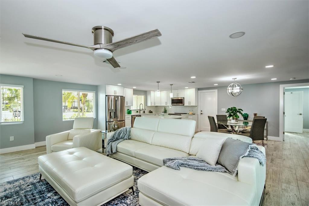 Living room with sink, ceiling fan, and light hardwood / wood-style flooring