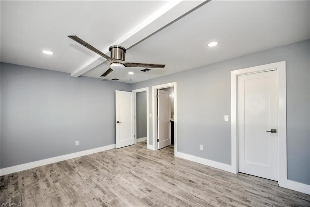 Unfurnished bedroom with ceiling fan, light hardwood / wood-style floors, and beamed ceiling