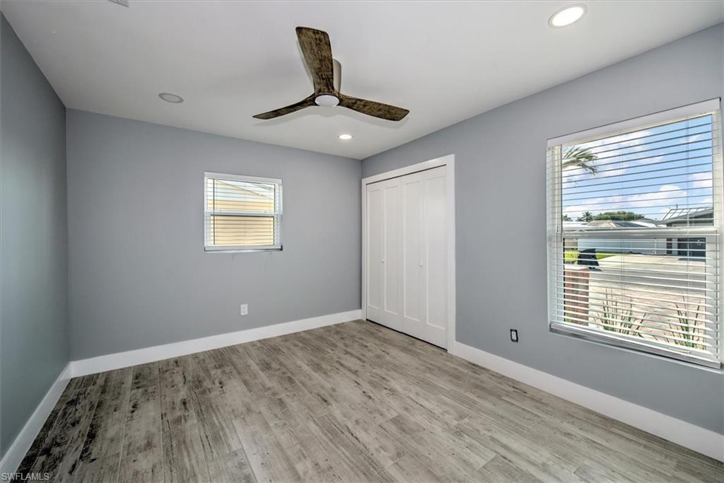 Unfurnished bedroom featuring light wood-type flooring, ceiling fan, and a closet