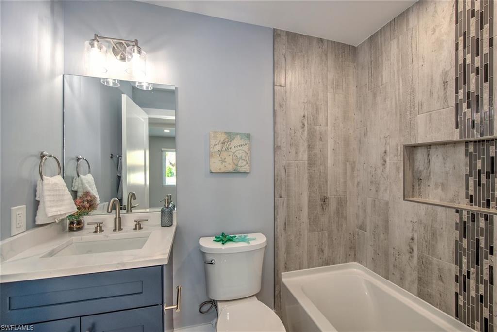 Full bathroom with toilet, shower / washtub combination, and vanity