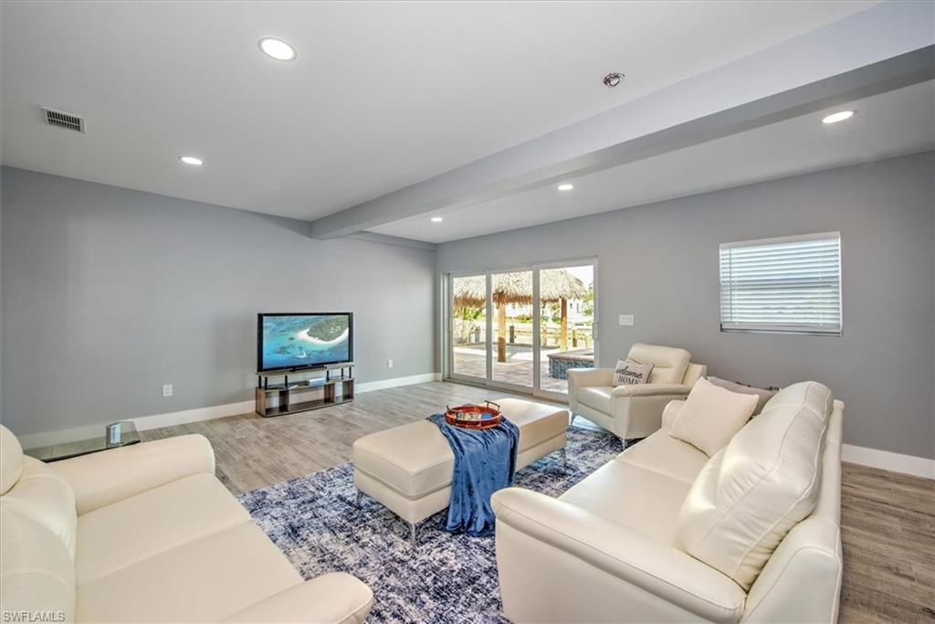 Living room with light wood-type flooring and beam ceiling