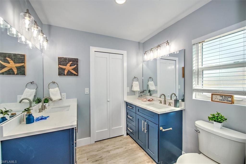 Bathroom featuring toilet, vanity, and wood-type flooring