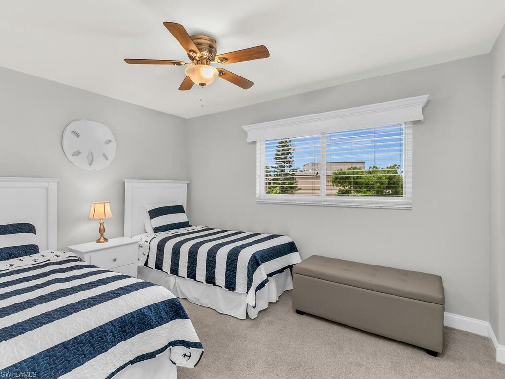 Bedroom with ceiling fan and light colored carpet