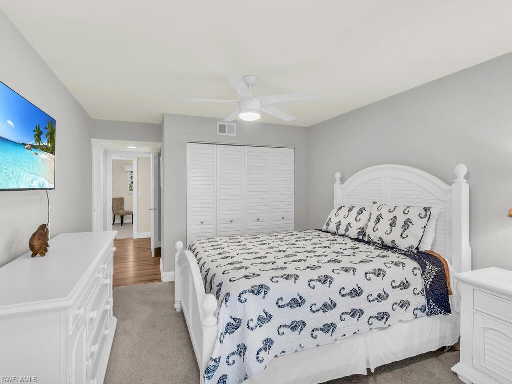 Bedroom with light carpet, a closet, and ceiling fan