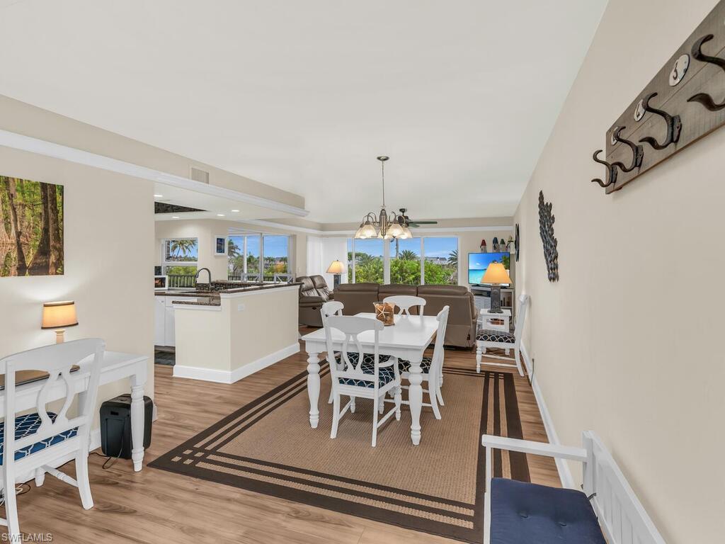 Dining space with light wood-type flooring, an inviting chandelier, and sink
