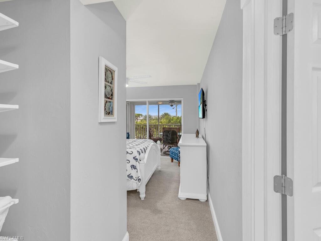 Hallway featuring light carpet