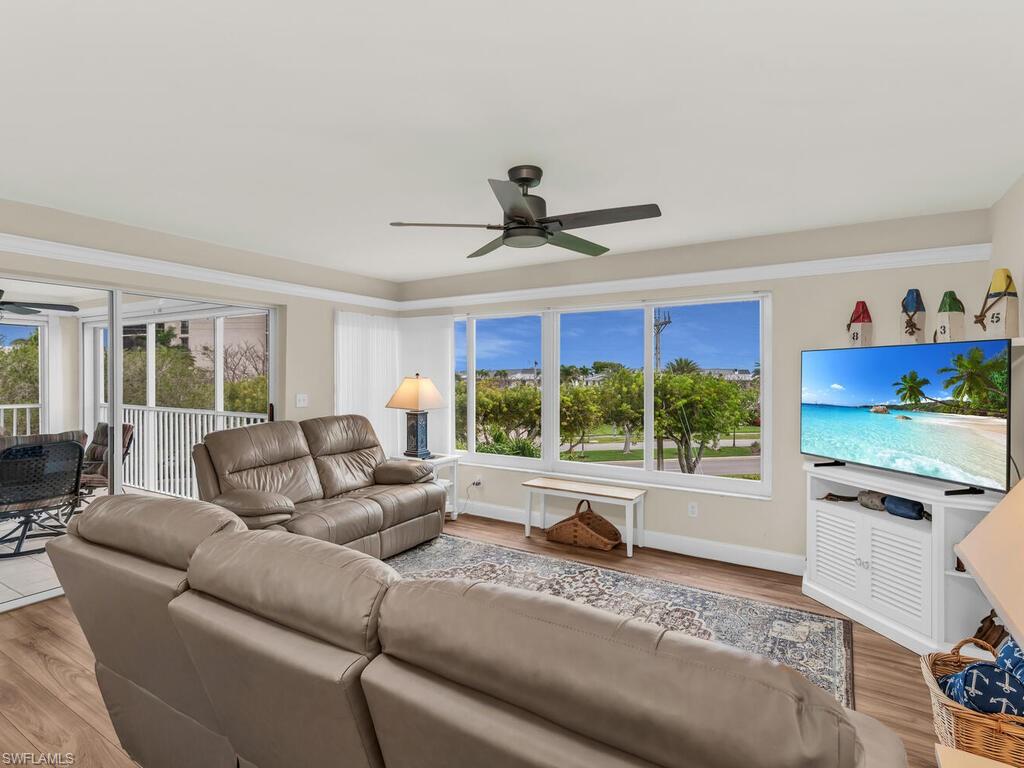 Living room with ceiling fan, light hardwood / wood-style floors, and plenty of natural light
