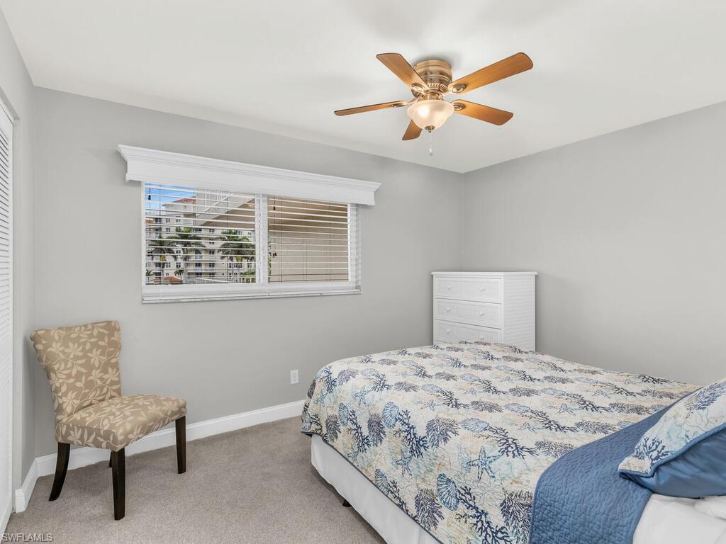 Bedroom with ceiling fan and light colored carpet