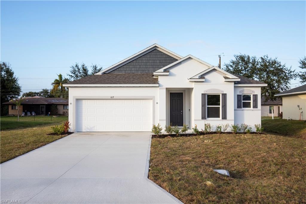 View of front of property featuring a front lawn, stucco siding, driveway, and a shingled roof