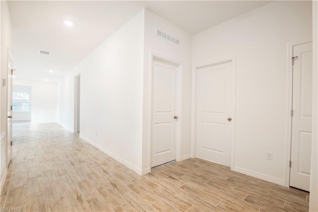 Corridor with wood finish floors and recessed lighting