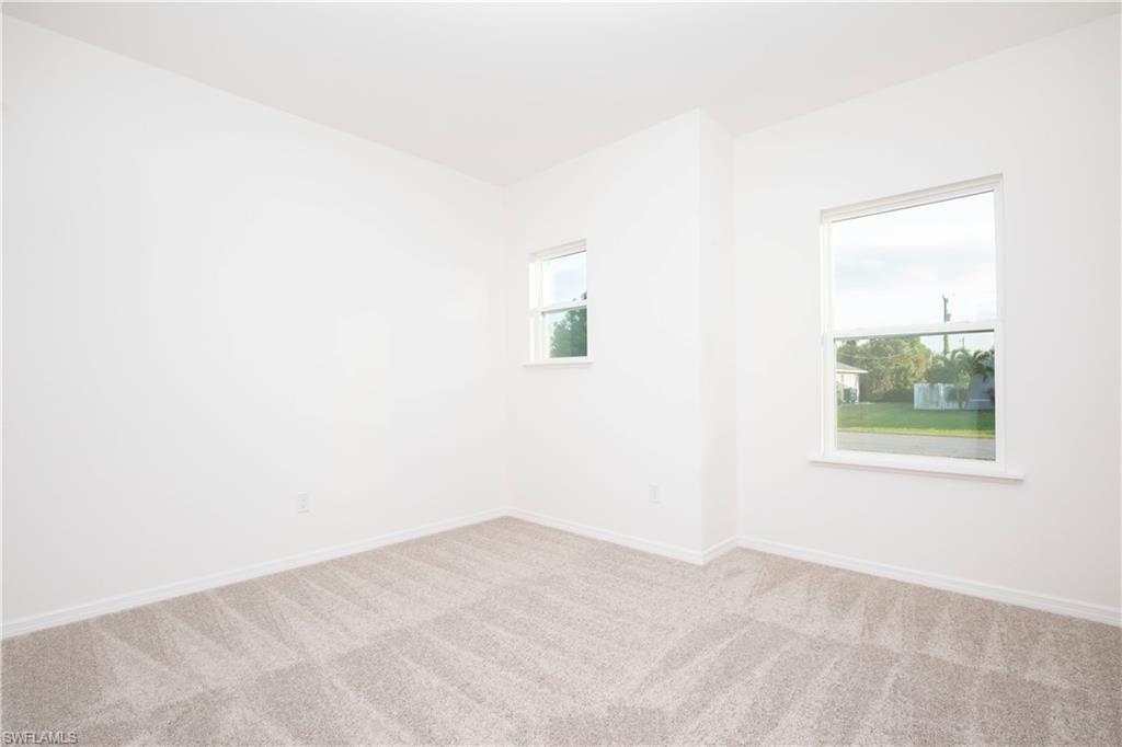 Carpeted spare room with baseboards