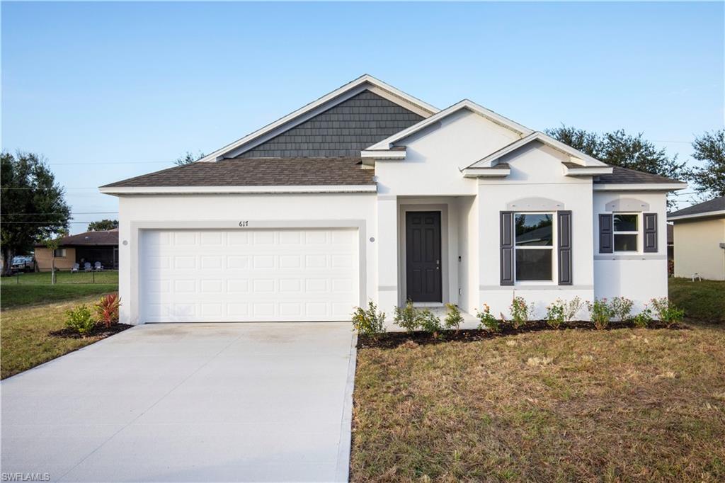 Ranch-style home featuring roof with shingles, stucco siding, and driveway