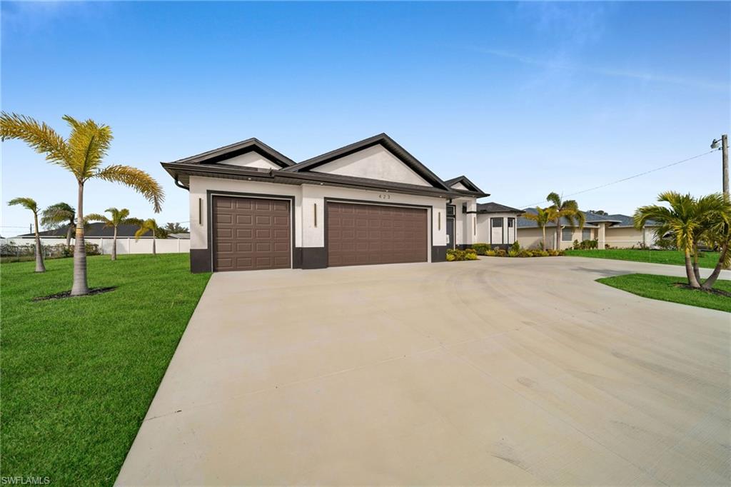 Single story home featuring a garage and a front yard
