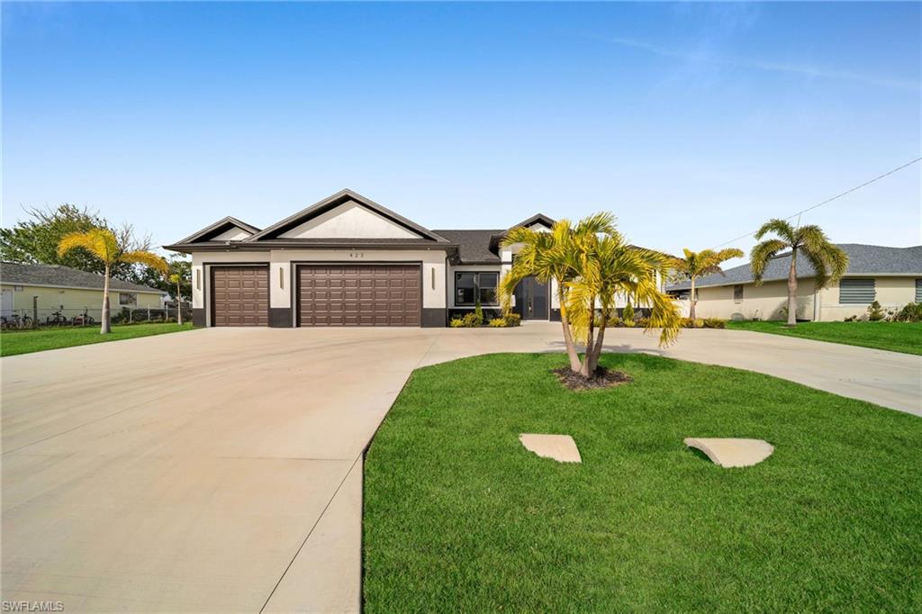 Ranch-style home featuring a front yard and a garage