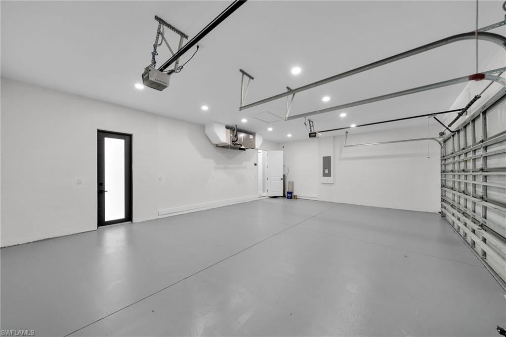 Garage featuring a garage door opener and electric panel