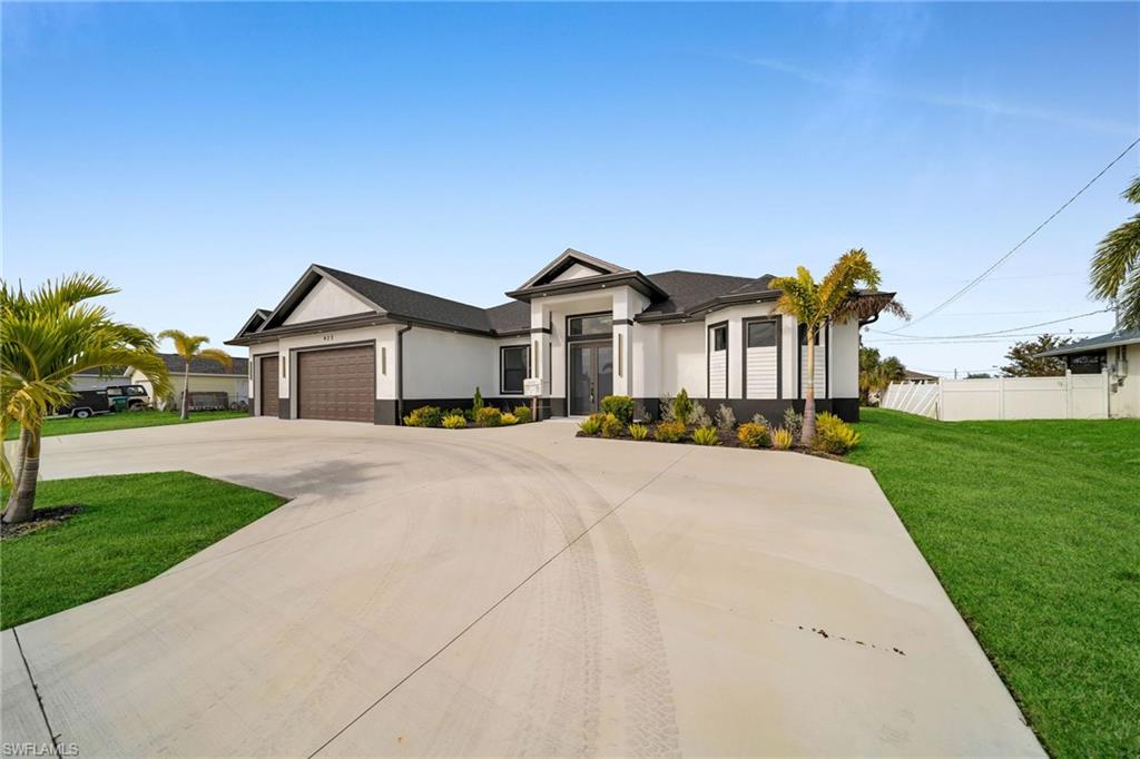View of front of property featuring a front yard and a garage