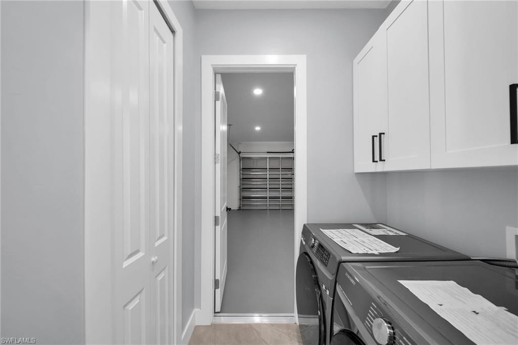 Laundry room featuring cabinets and washing machine and clothes dryer