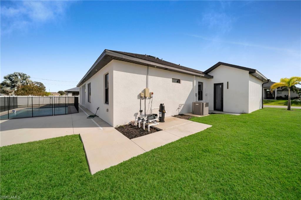 Back of house with a fenced in pool, central AC, a yard, and a patio