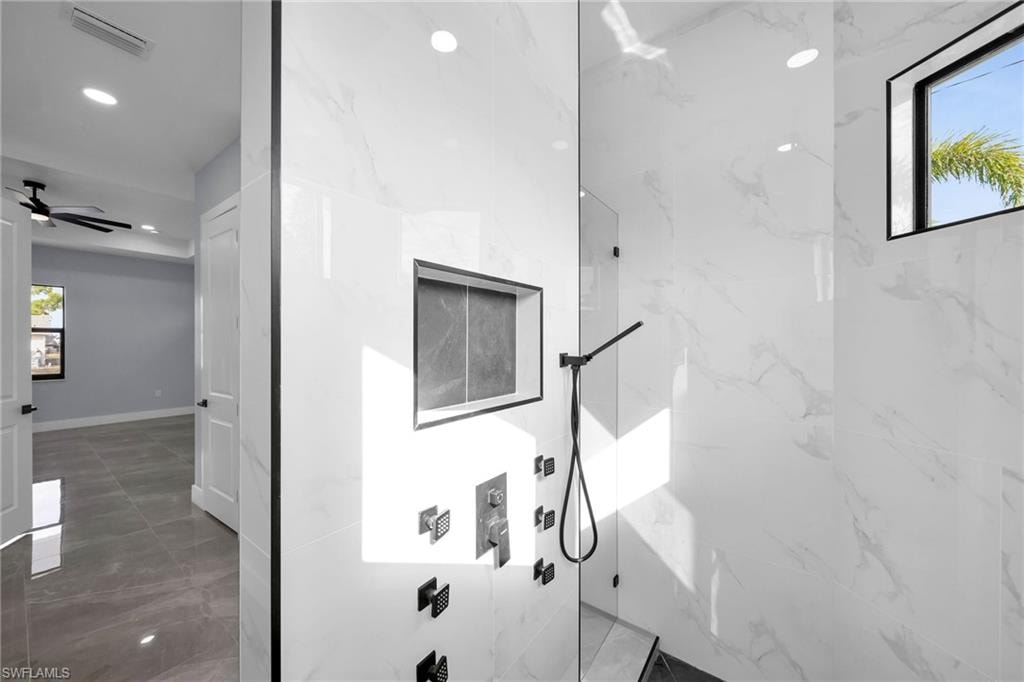 Bathroom with ceiling fan and a shower