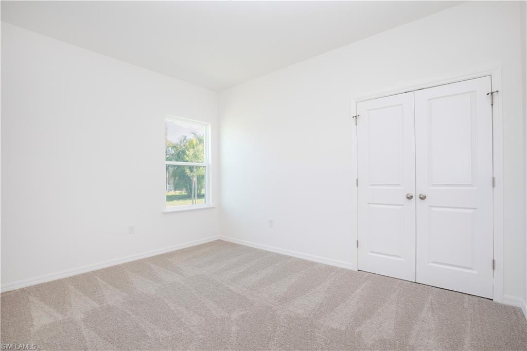 Unfurnished bedroom with carpet flooring and a closet