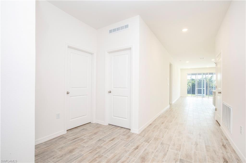 Corridor featuring wood tiled floors and recessed lighting