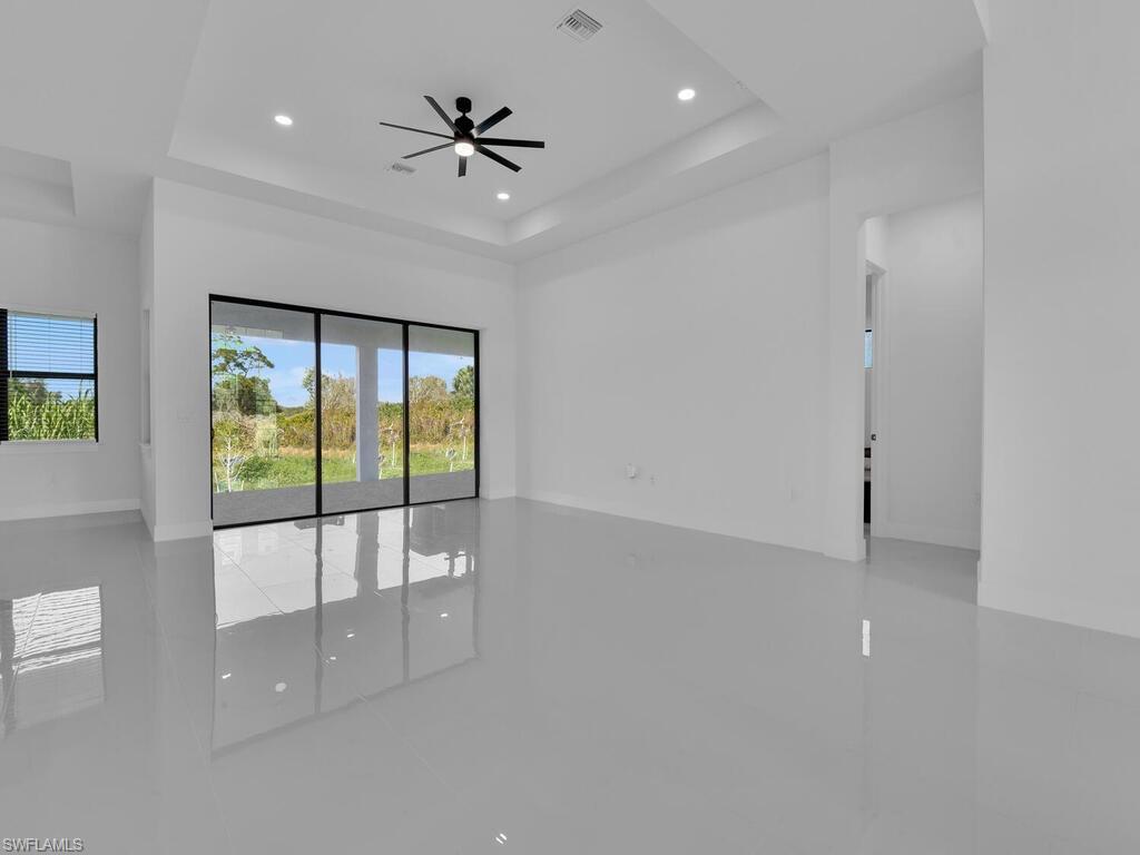 Tiled spare room with ceiling fan and a raised ceiling