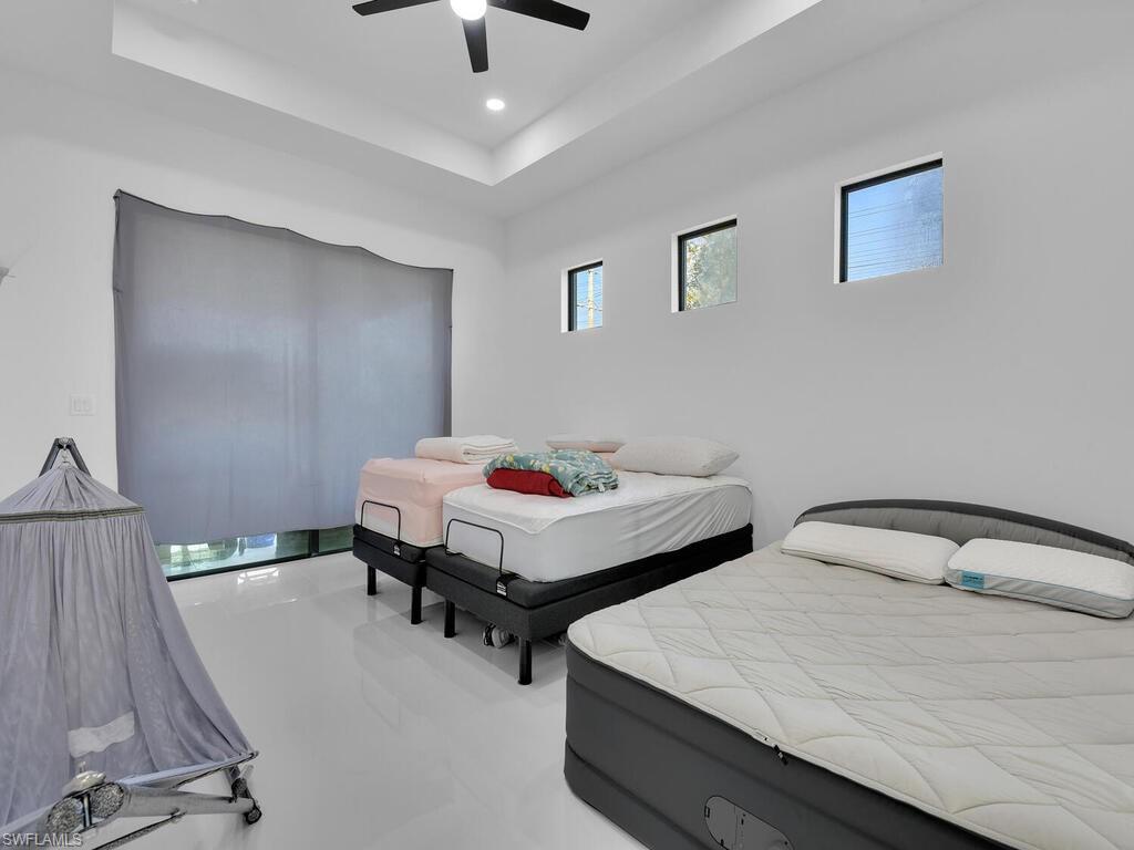 Bedroom with ceiling fan and a tray ceiling