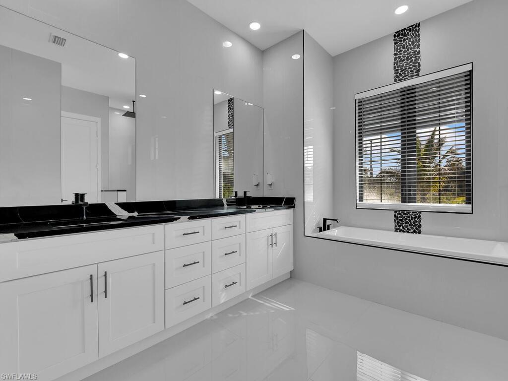 Bathroom featuring vanity, a bathing tub, and tile patterned flooring