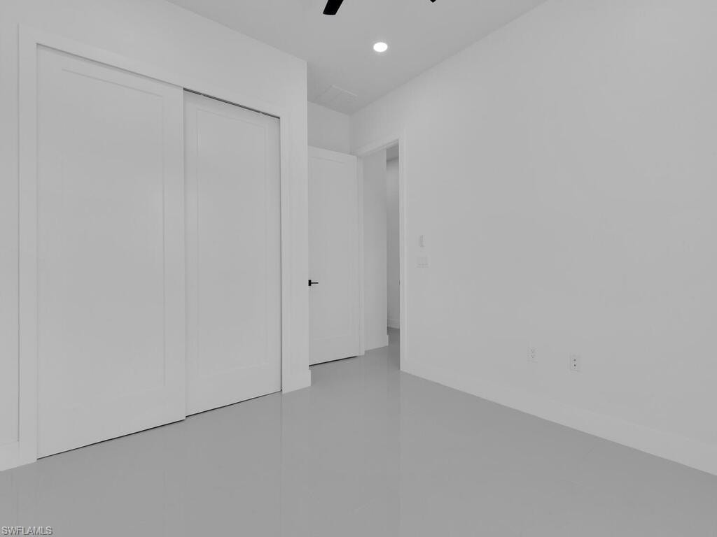 Unfurnished bedroom with ceiling fan and a closet