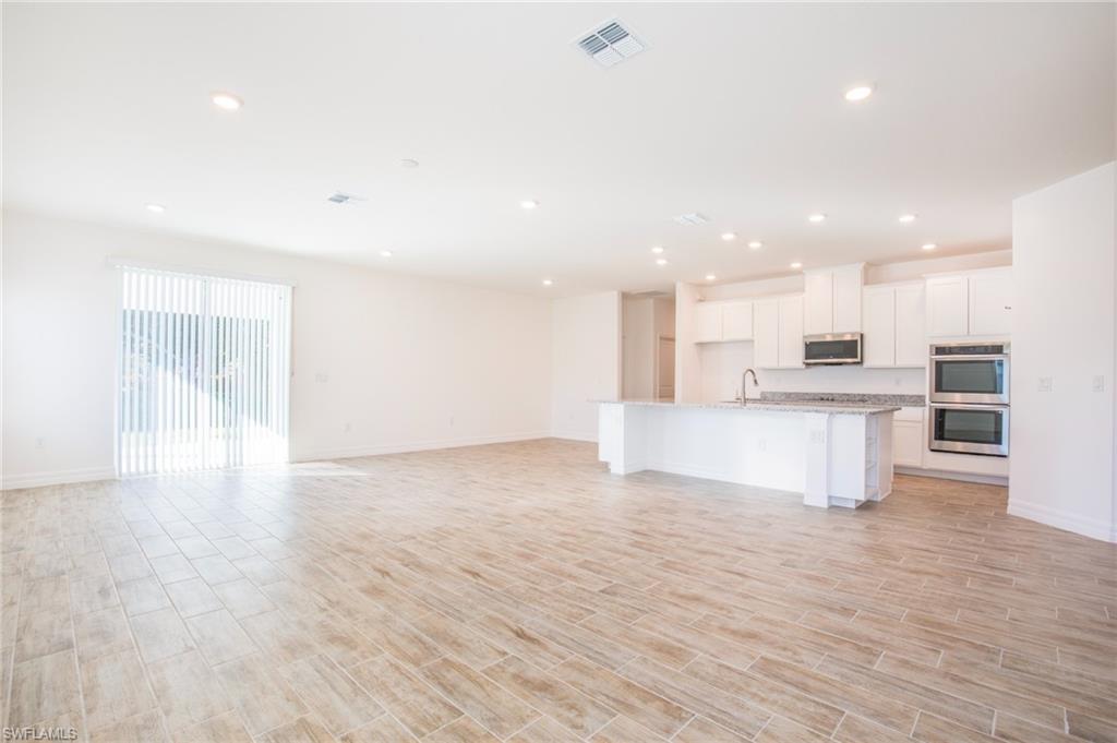 Unfurnished living room with wood tiled floors and recessed lighting