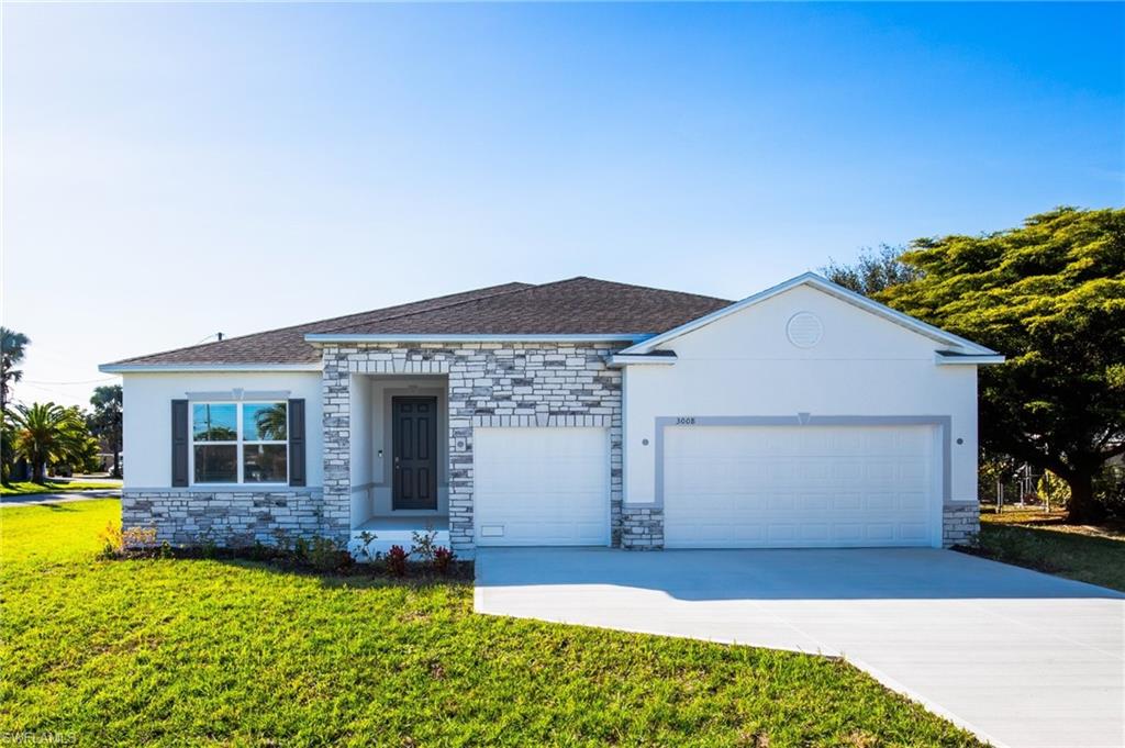 Ranch-style home featuring stone siding, a front lawn, and concrete driveway