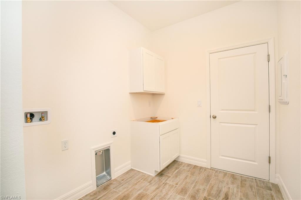 Laundry room with cabinet space, washer hookup, wood finish floors, electric panel, and hookup for an electric dryer