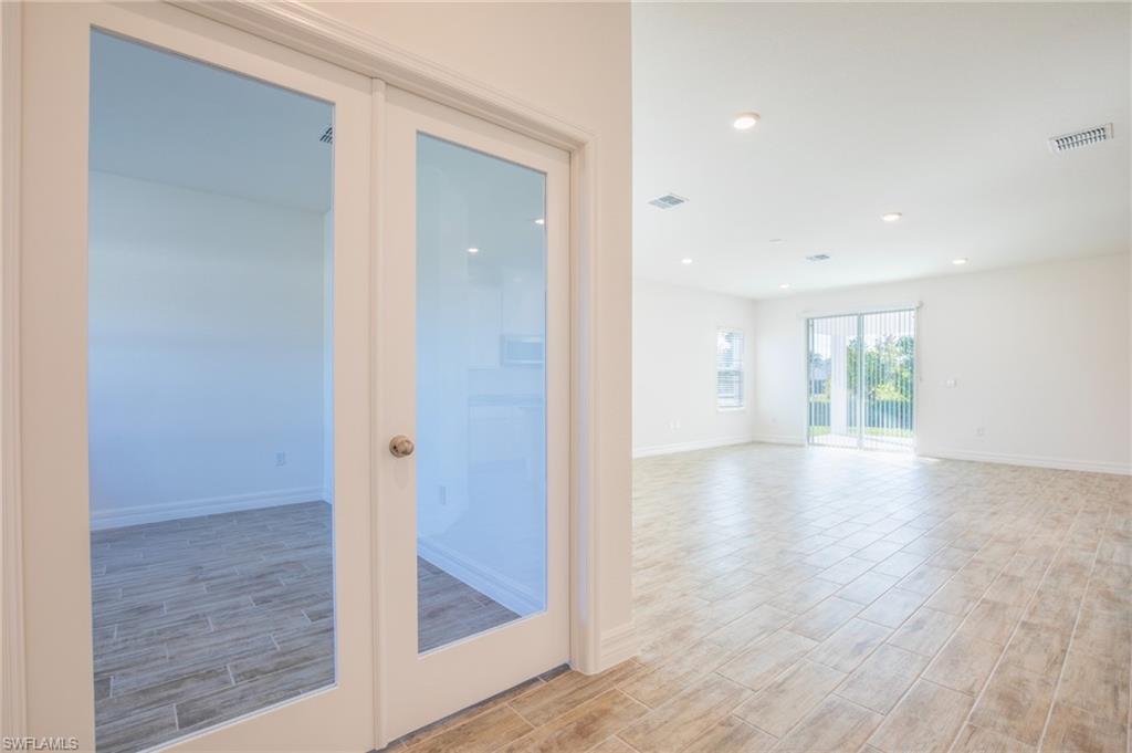 Spare room with wood tiled floors, french doors, and recessed lighting