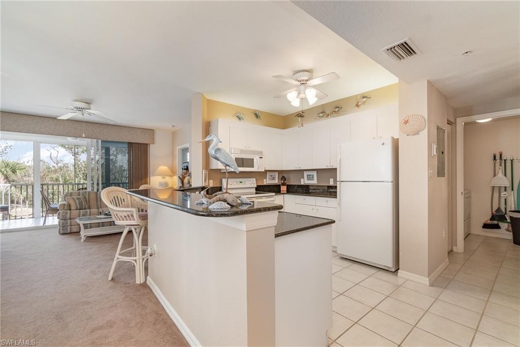 Kitchen featuring ceiling fan, light tile patterned floors, white cabinets, and white appliances