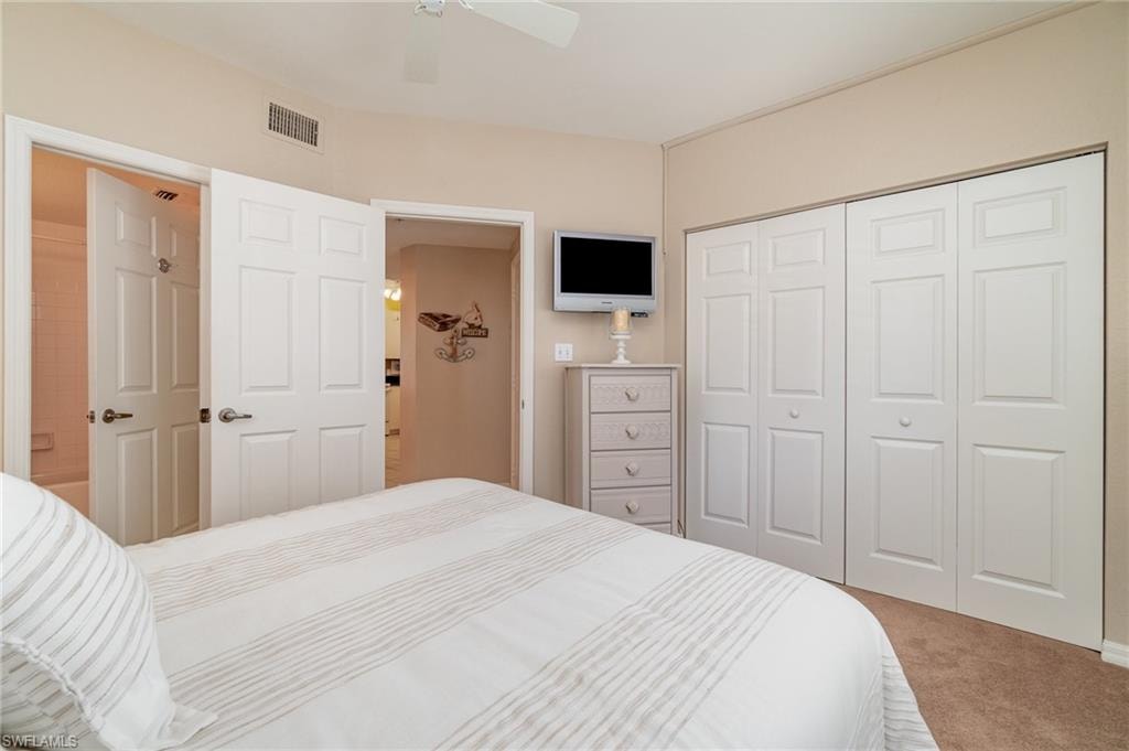 Carpeted bedroom with a closet and ceiling fan