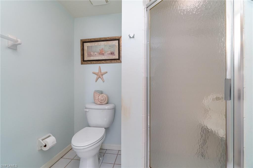 Bathroom with tile patterned flooring, walk in shower, and toilet