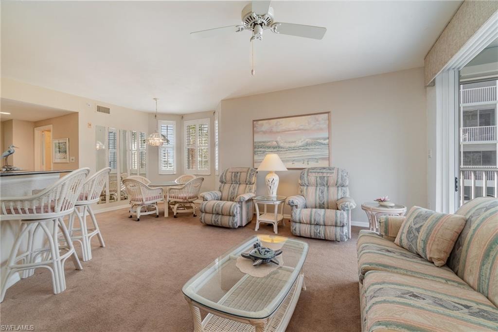 Living room featuring light colored carpet and ceiling fan