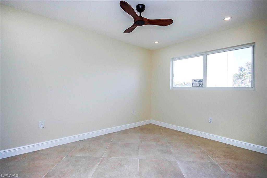 Tiled spare room with ceiling fan
