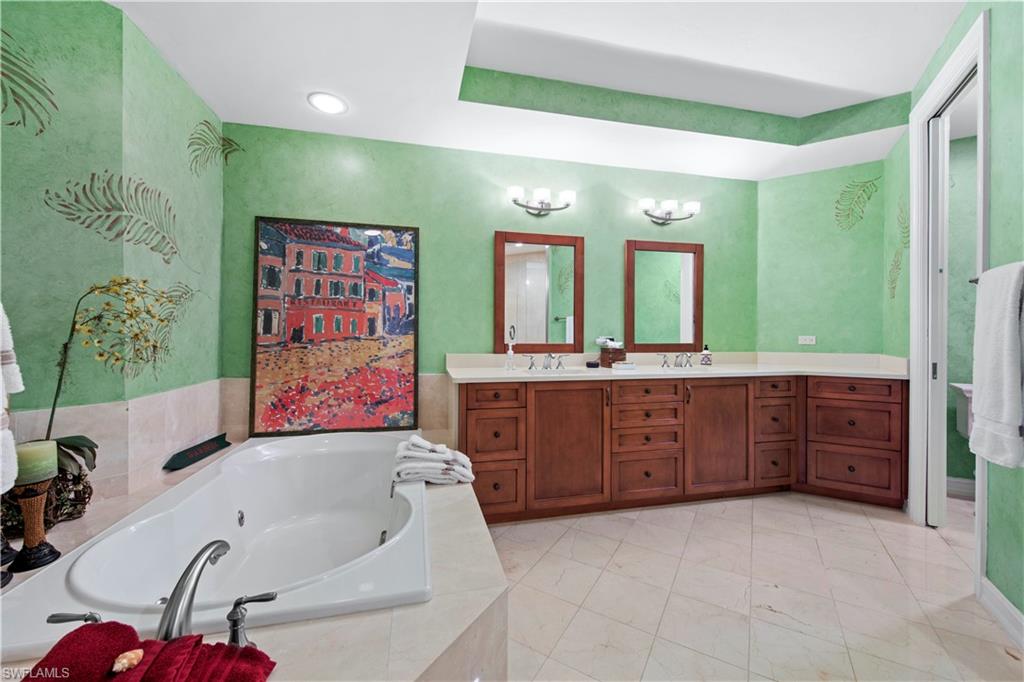 Bathroom with tiled tub and vanity