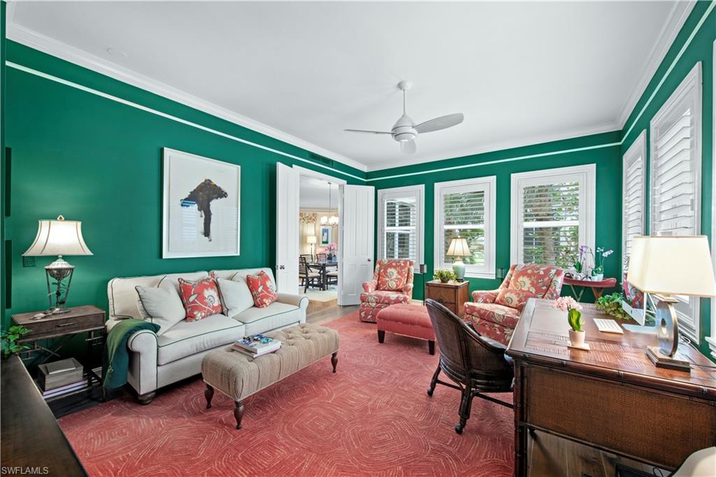 Living room featuring ceiling fan and ornamental molding