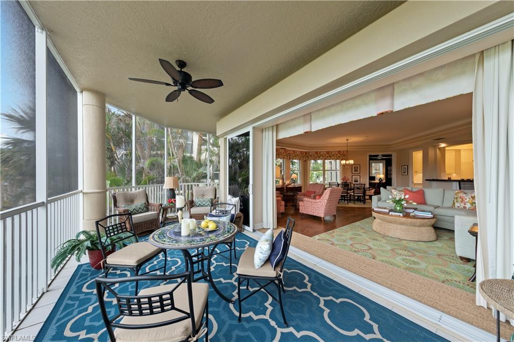Sunroom / solarium featuring ceiling fan with notable chandelier