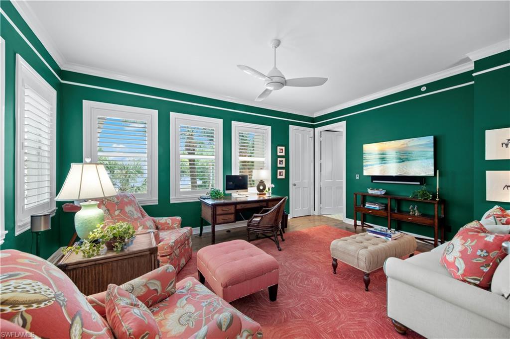 Living room with crown molding and ceiling fan