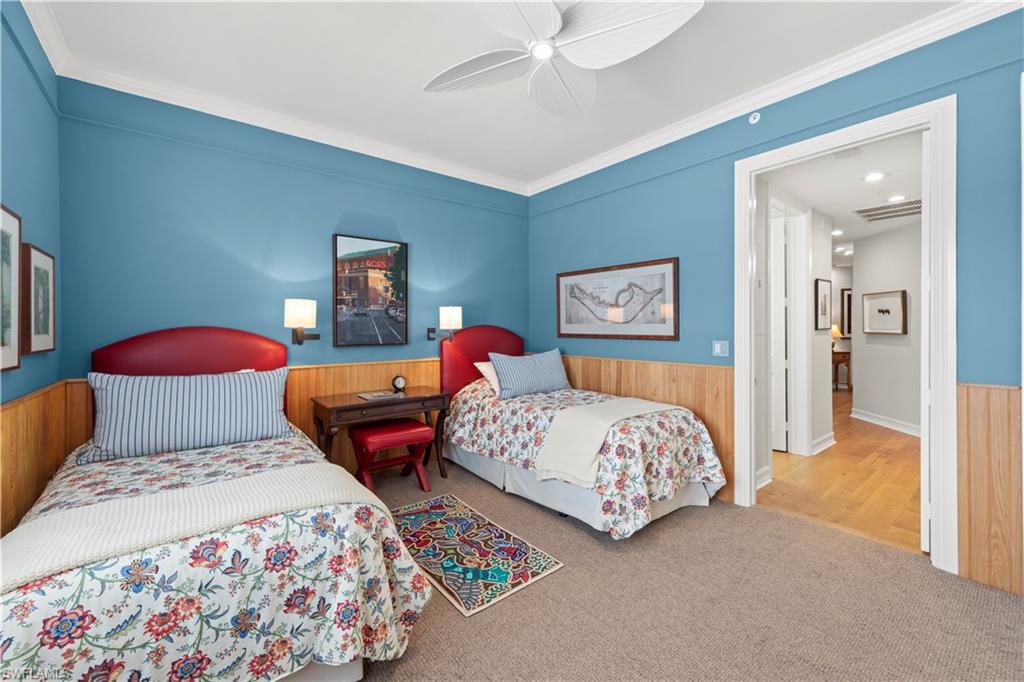 Bedroom with ceiling fan, carpet, and crown molding