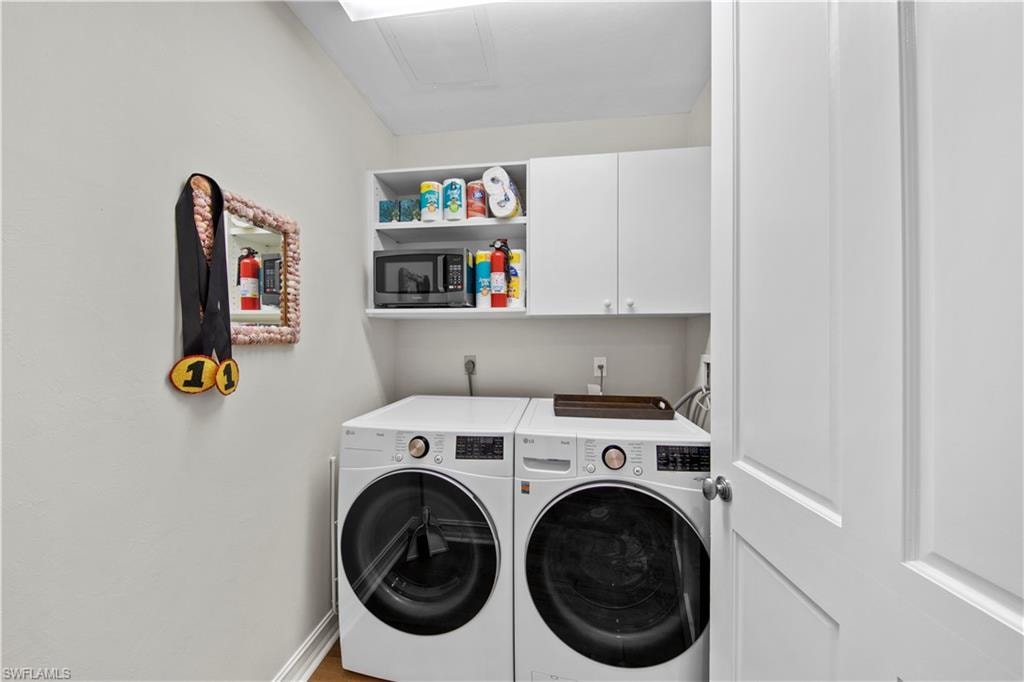 Laundry room with separate washer and dryer and cabinets