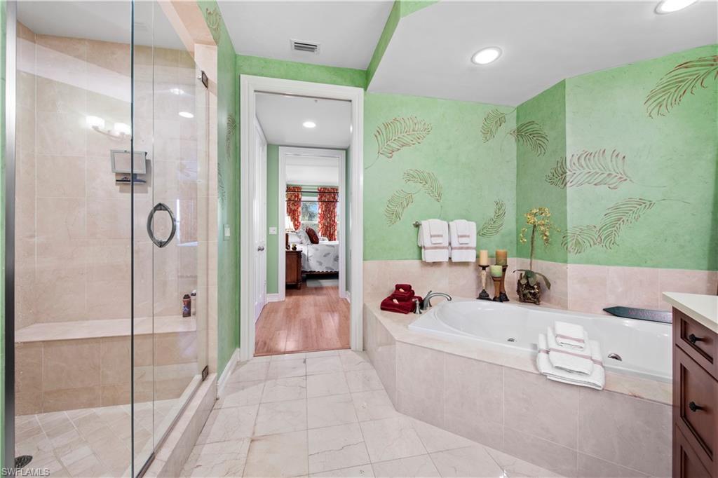 Bathroom featuring separate shower and tub and vanity