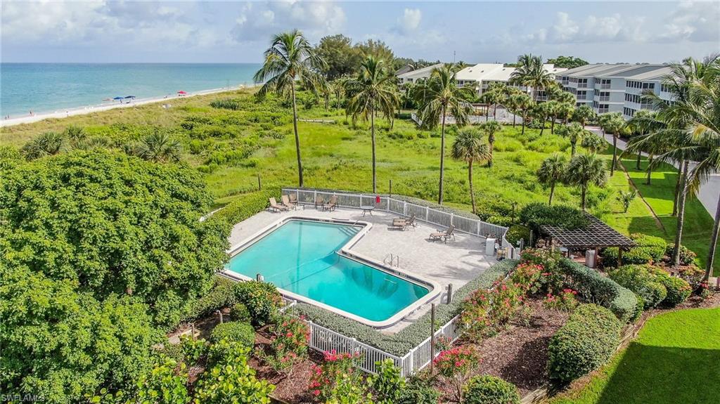 View of pool with a water view, a beach view, and a patio area