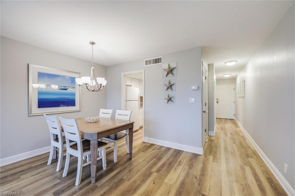 Dining room with a notable chandelier and light hardwood / wood-style floors