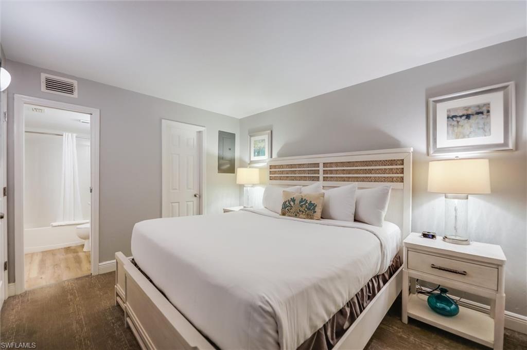 Bedroom with ensuite bathroom and dark hardwood / wood-style flooring