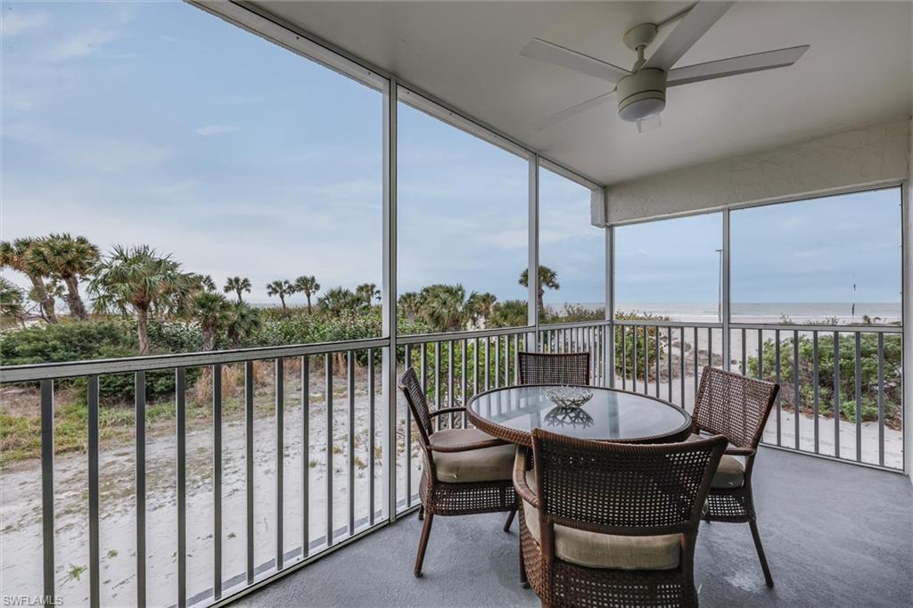 Sunroom featuring a water view, a beach view, and ceiling fan