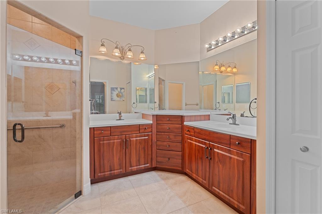 Bathroom featuring tile patterned floors, walk in shower, and vanity
